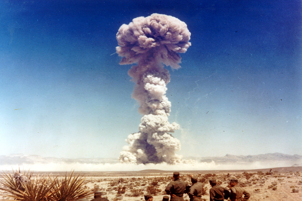 A mushroom cloud from a nuclear weapons test in the desert.