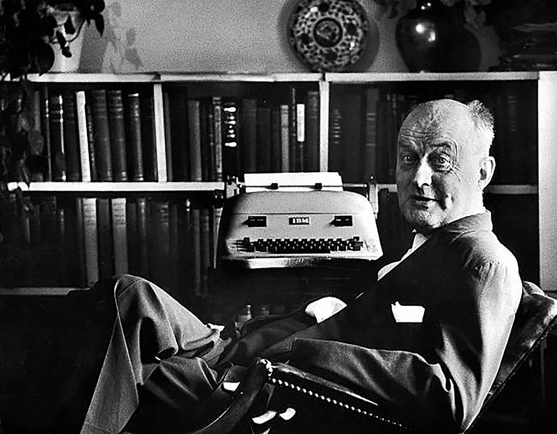 Black and white image of a seated Reinhold Niebuhr in his office.